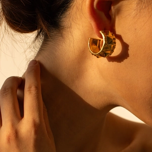 Close-up of 18k gold plated stainless steel C-shaped earring with pyramid stud design