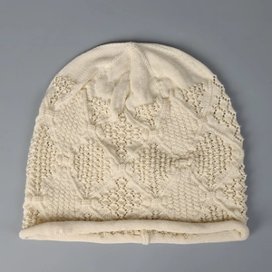 Detailed texture of a beige hollow-out knitted slouchy beanie for spring and summer use.