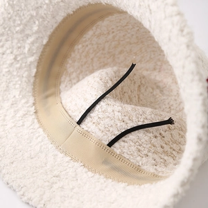 Detail of white plush bucket hat interior with adjustable drawstring for customized fit