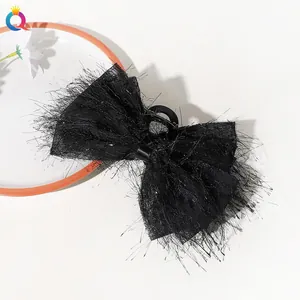 Detail of elegant black chiffon bow hair claw clip with layered fringe and mesh texture