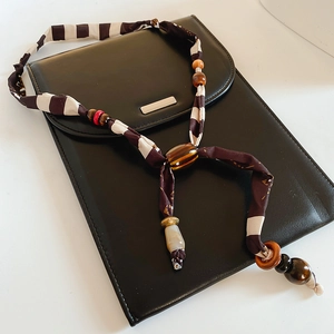 Close-up of striped fabric beads and wooden accents on a stylish brown layered necklace