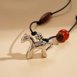 Detail of silver pony pendant with vintage wooden beads and black woven cord necklace