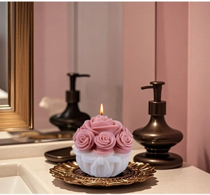 Candela profumata a mazzo di rose rosa con base bianca e fiocco in interno elegante