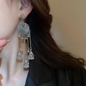 Detail of vintage bohemian silver earrings with dangling chain tassels and bells