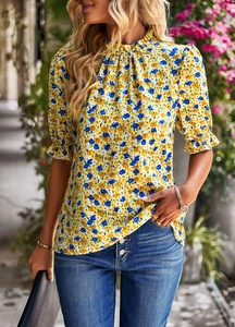 Détail d'un chemisier à imprimé floral avec manches pétales et col montant sur mannequin