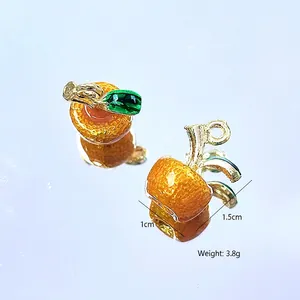 Detail showing orange-shaped resin pendants with textured skin and green leaves