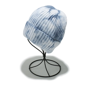 Detailed knit texture and folded cuff of blue and white tie-dye winter beanie