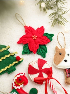 Close-up of felt Christmas ornaments including flowers and trees on soft white fur background