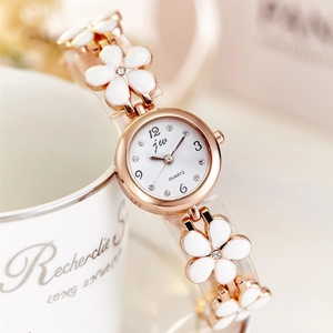 Rose gold quartz bracelet watch with white floral ceramic charms and crystal dial markers
