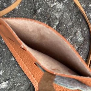 Detail view of mini brown lychee texture leather crossbody bag showing inner compartment