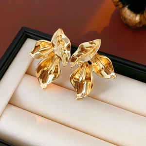 Gros plan détaillé de boucles d'oreilles pétales dorées dans une boîte à bijoux de luxe