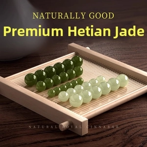Close-up of natural Hetian jade beads in dark and light green on a wooden tray