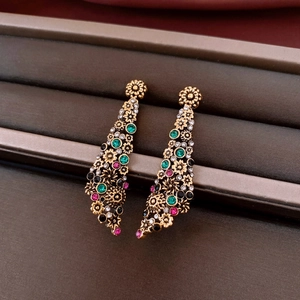 Dettaglio di orecchini vintage con cristalli multicolori in una scatola di velluto