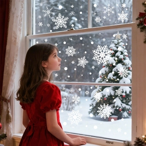 Girl standing by a window decorated with white snowflake static decals and winter snow scenery