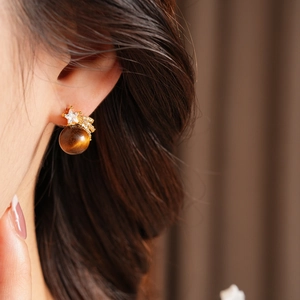 Vue détaillée de boucles d'oreilles de luxe en œil de tigre avec étoiles en zircon