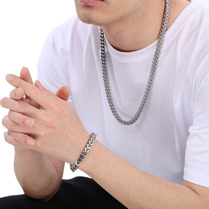 Detailed view of silver stainless steel keeled chain necklace and bracelet on model