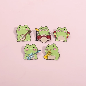 Detailed view of 5 cute enamel frog pins playing musical instruments on pink background