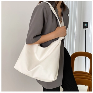 Minimalist white leather tote bag shown from a side view on model for everyday style