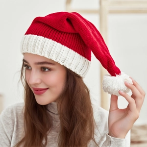 Bonnet de Noël en tricot rouge et blanc avec pompon blanc porté par un mannequin