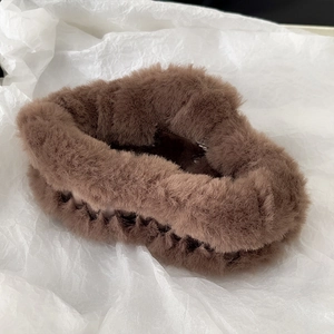 Close-up of a large brown plush hair claw clip with soft faux fur texture for women