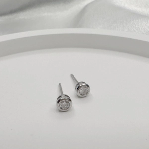 Close-up of minimalist S925 sterling silver stud earrings with round cubic zirconia stones