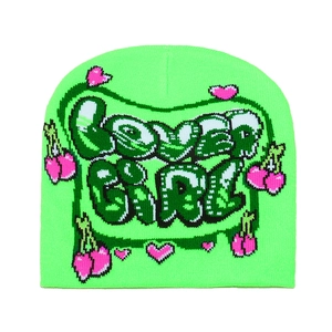Close-up of knit texture with 'lover girl' lettering and neon green cherry heart patterns
