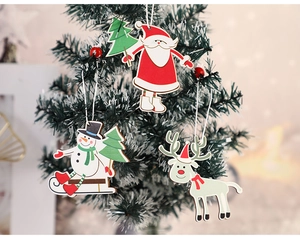 Close-up of wooden Santa, snowman, and reindeer ornaments hanging on a Christmas tree