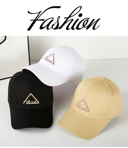 Detailed close-up of cotton baseball caps in black, white, and khaki with triangle embroidery