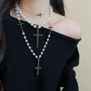 Detail einer dreilagigen Perlenkette mit schwarzen Strass-Kreuzanhängern für Damen