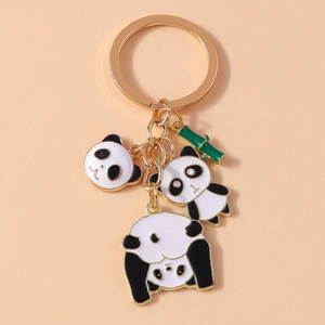Detail of gold keychain with black and white enamel pandas and green bamboo charms
