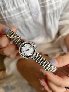 Close-up of elegant silver ladies watch with diamond bezel and Roman numeral dial