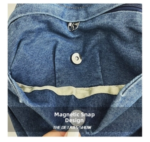 Detail of the magnetic snap button and inner zipper on a blue denim backpack