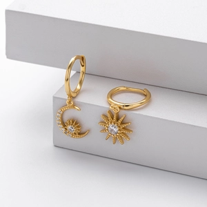 Detail of asymmetric gold S925 silver earrings with moon, star, and sun zircon studs