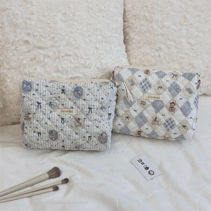 Détail des trousses de maquillage en coton matelassé avec motif ours et fermeture éclair