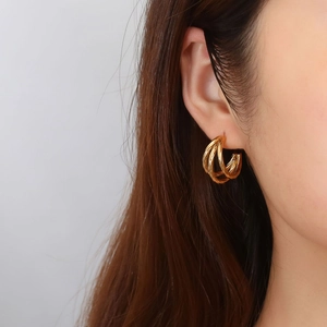 Chic 18K gold plated twisted stainless steel triple hoop earrings worn by a model