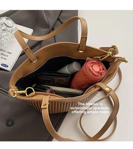 Spacious interior of a pleated brown tote bag showing capacity for daily essentials