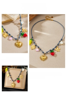 Detail of blue cord necklace with golden sun heart, clover and floral charms