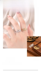 Detail of adjustable hollow heart rings in gold and silver finishes on a model's hand