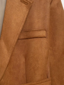 Detail of premium brown suede blazer showing fine fabric texture and pocket stitching