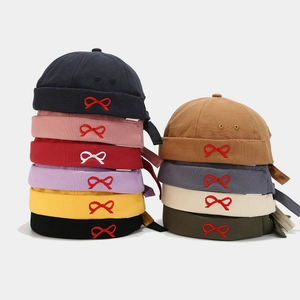 Multiple colors of cotton miki hats with bow embroidery stacked in two neat rows