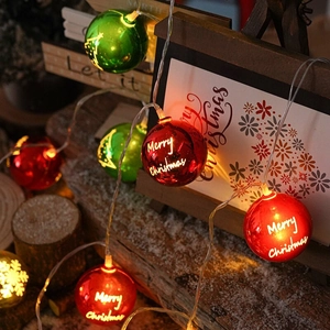 Colorful Merry Christmas LED ball string lights on rustic wooden stand for holiday decor
