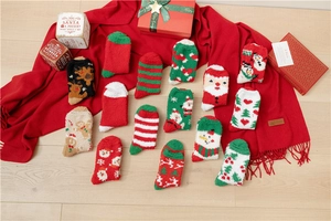 Flat lay of colorful coral fleece Christmas socks featuring Santa and reindeer patterns