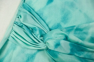 Detail of teal tie-dye mesh fabric with elegant twist knot and ruched texture design