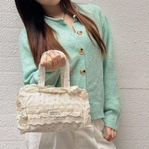 Détail du sac cabas en toile avec bordure en dentelle et motifs floraux brodés