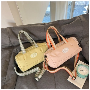 Detail view of yellow and pink cylinder sports bags with adjustable striped shoulder straps