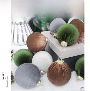 Close-up of velvet Christmas ornaments with gold hooks and textured fabric surface