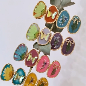 Artistic dried flower rings with gold oval base and butterfly resin charms on branch