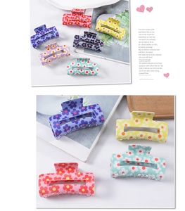 Detailed view of colorful floral square hair claws on a rustic wooden tray decoration