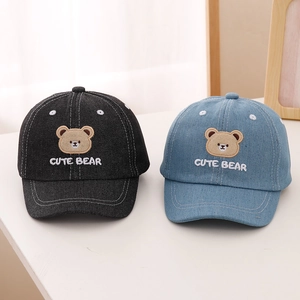 Detailed view of children's denim baseball caps featuring cute bear embroidery and stitching