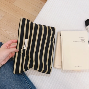 Macro detail of simple wish woven label on striped cotton canvas cosmetic makeup bag